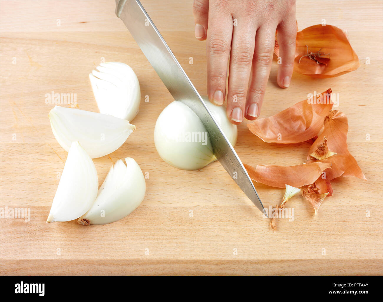 Chopping an onion using a large kitchen knife Stock Photo Alamy
