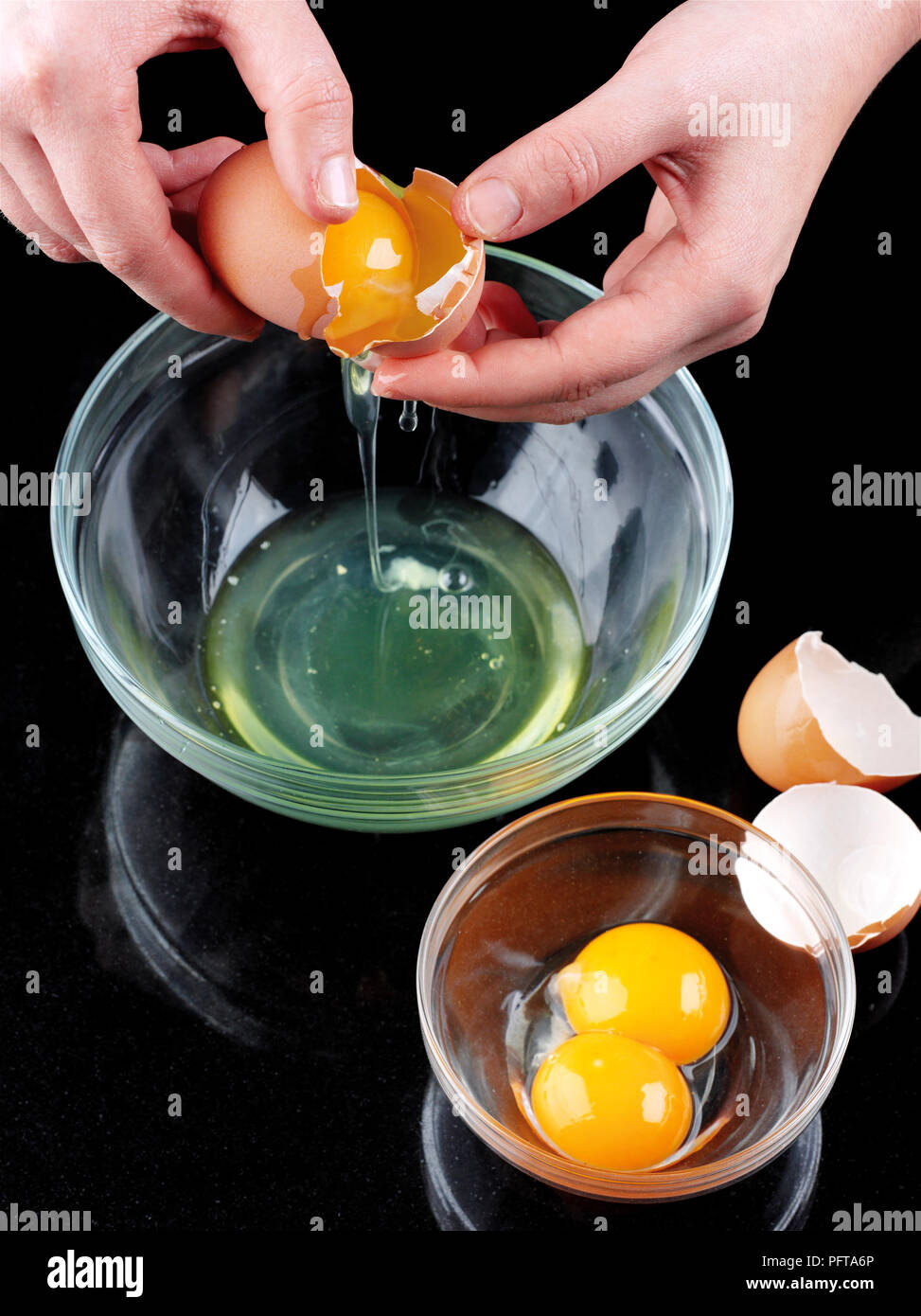 Separating egg yolks from egg whites Stock Photo Alamy