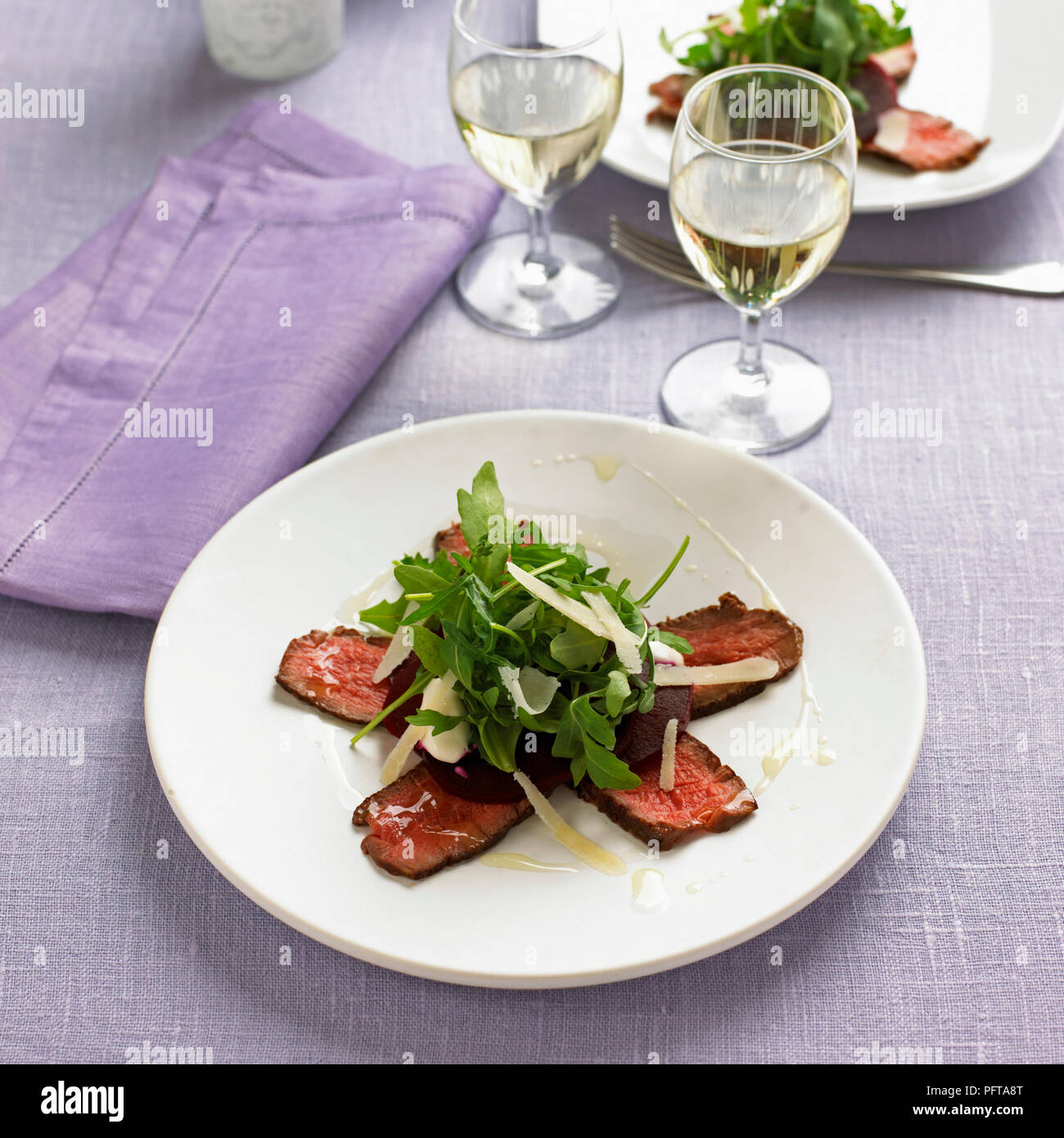 Fillet of beef with beetroot and horseradish dressing, garnished with rocket and parmesan Stock Photo
