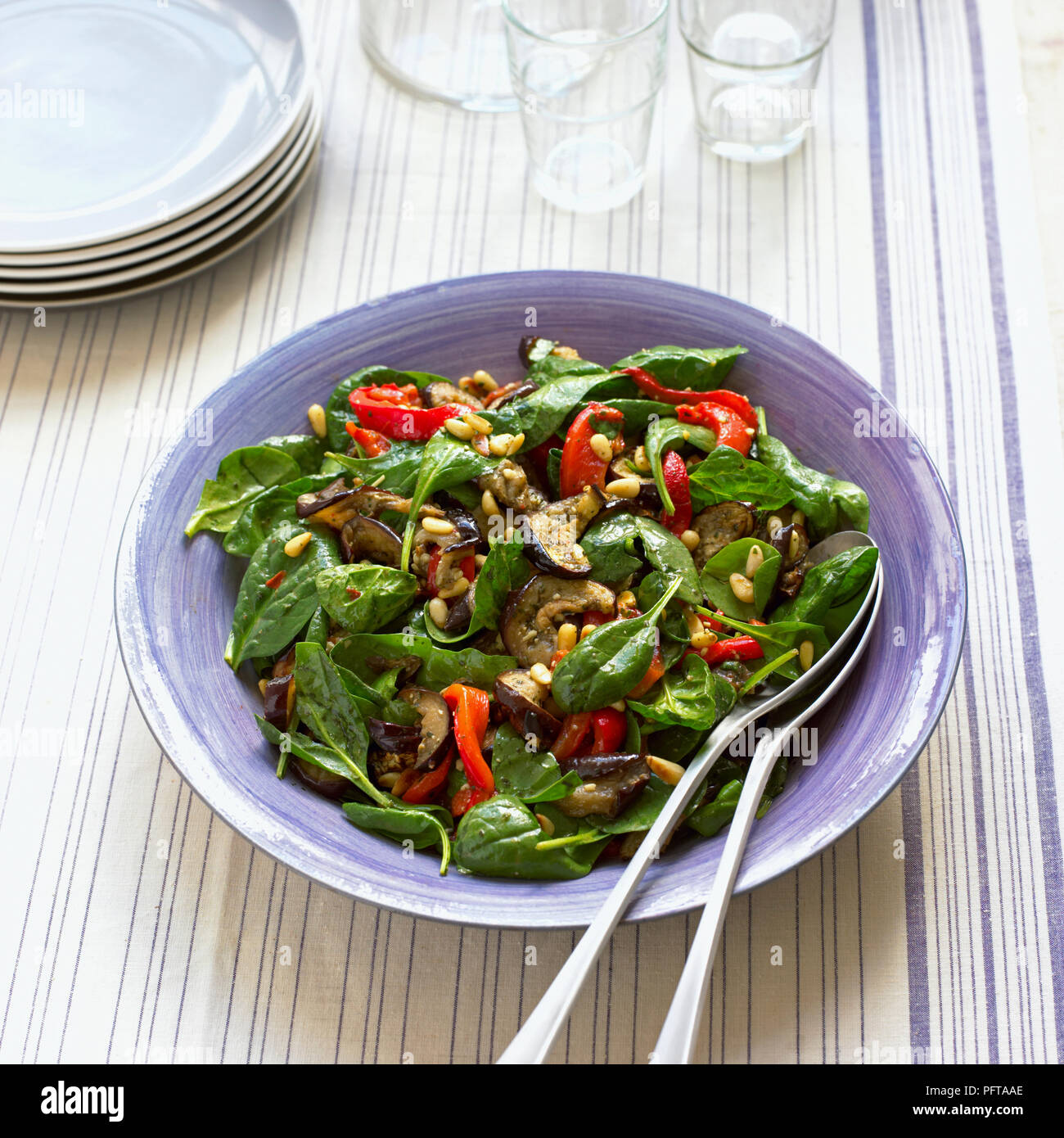 Red pepper, aubergine and spinach salad with pine nuts and basil dressing Stock Photo
