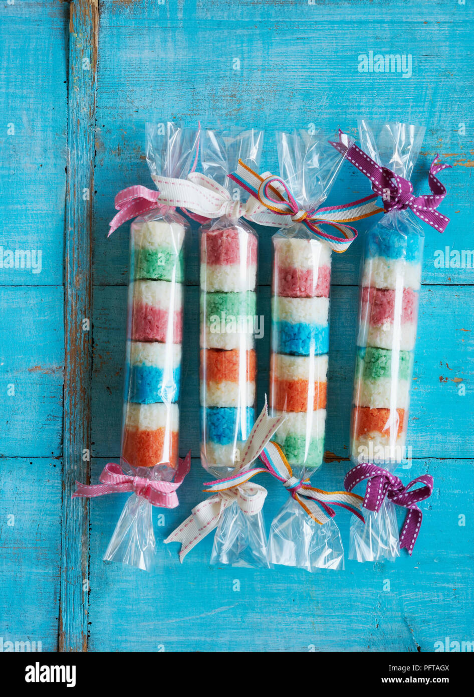 Coconut bites using different colours of food colourant, wrapped up in plastic and ribbon ties Stock Photo