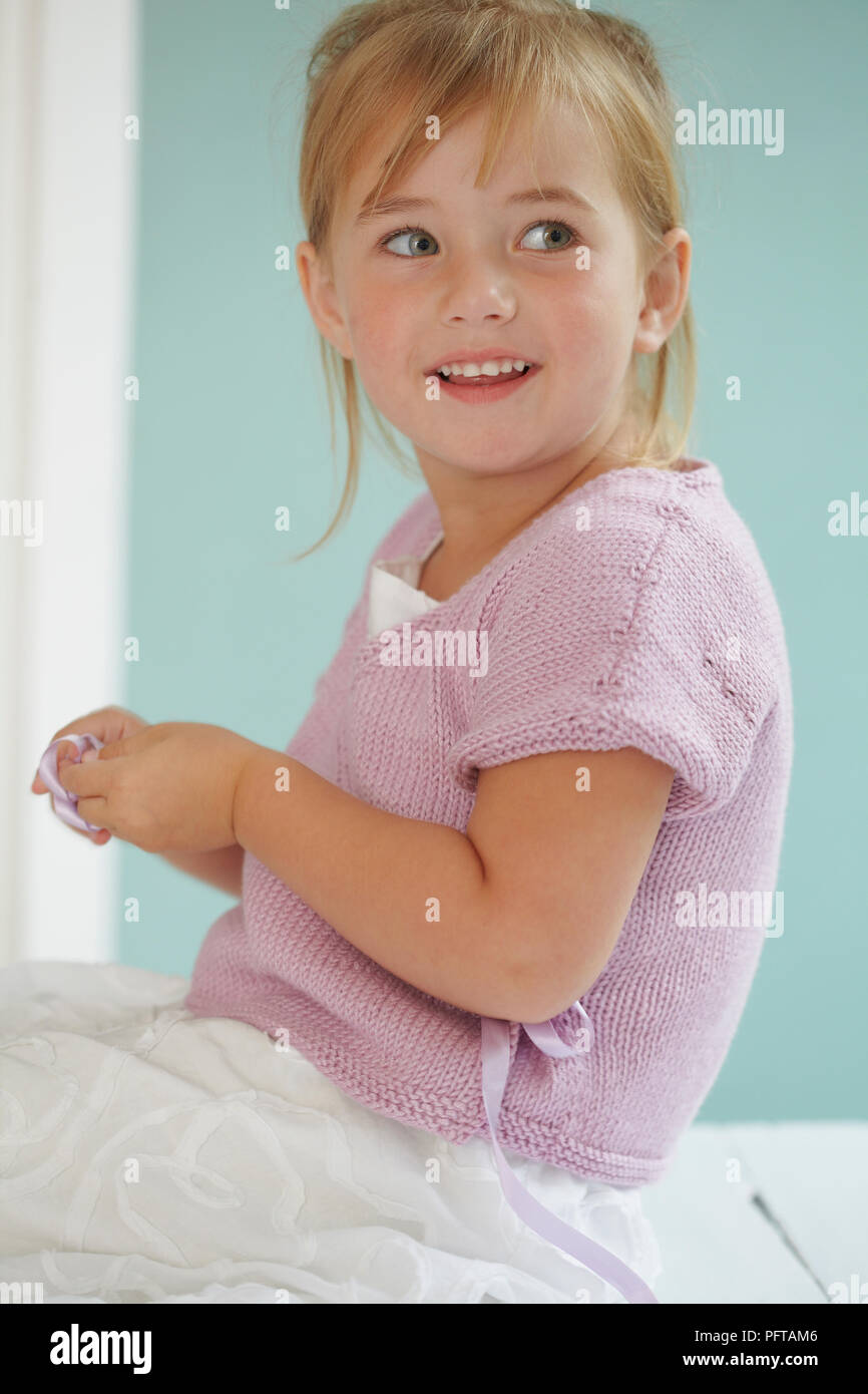 Girl wearing wraparound short sleeved pink cardigan, 4 years Stock Photo