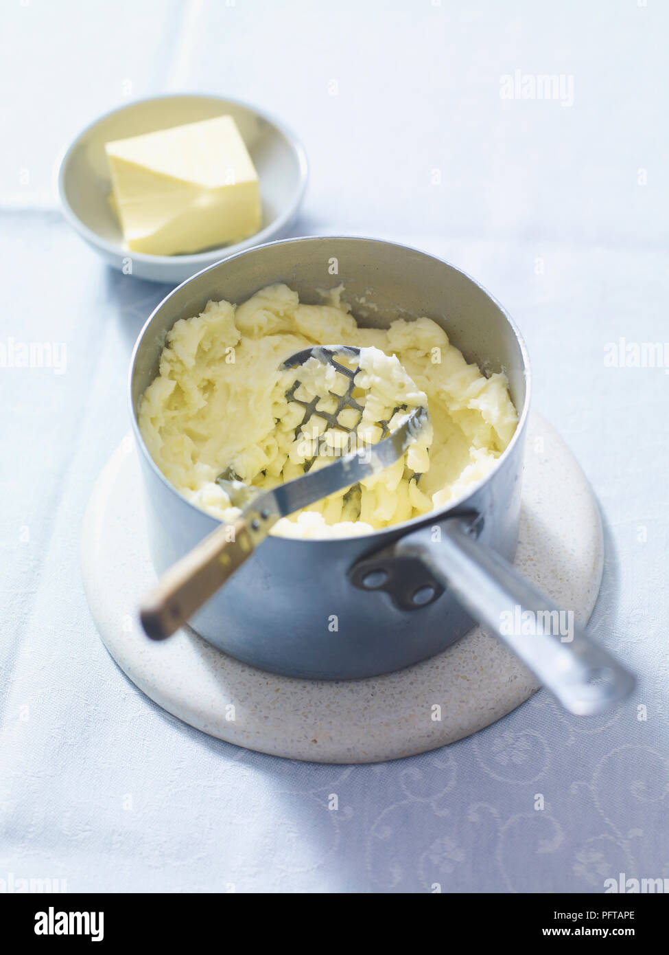 Making mashed potatoes, using potato masher Stock Photo