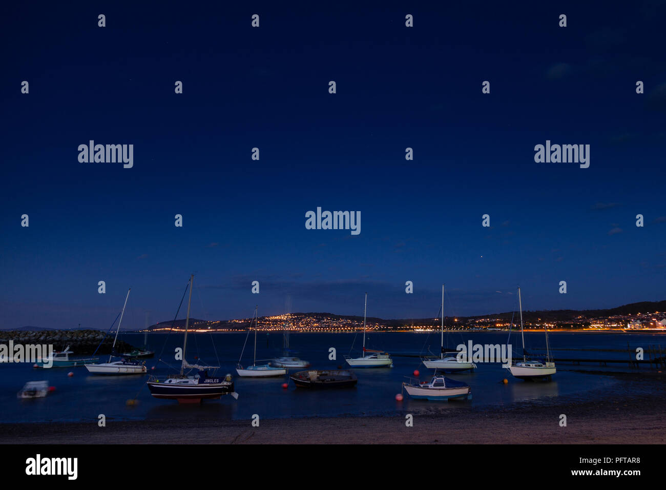 Small boats at night in Rhos-on-Sea harbour on the North Wales coast Stock Photo
