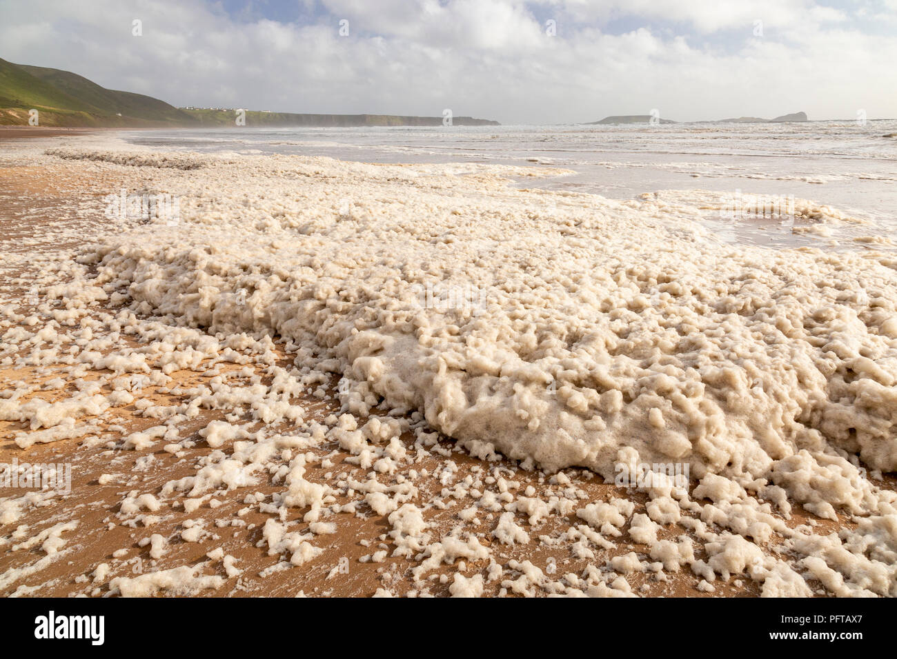 Foam pollution on Rhossili beach on the South Wales coast Stock Photo