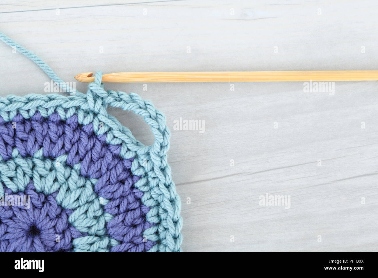 Blue crocheted pot holder, with yarn and hook Stock Photo