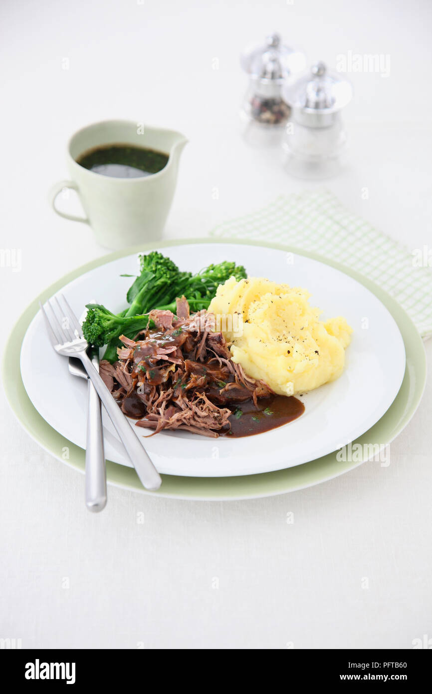 Shoulder of lamb with minty gravy, served with broccoli and mashed potatoes Stock Photo