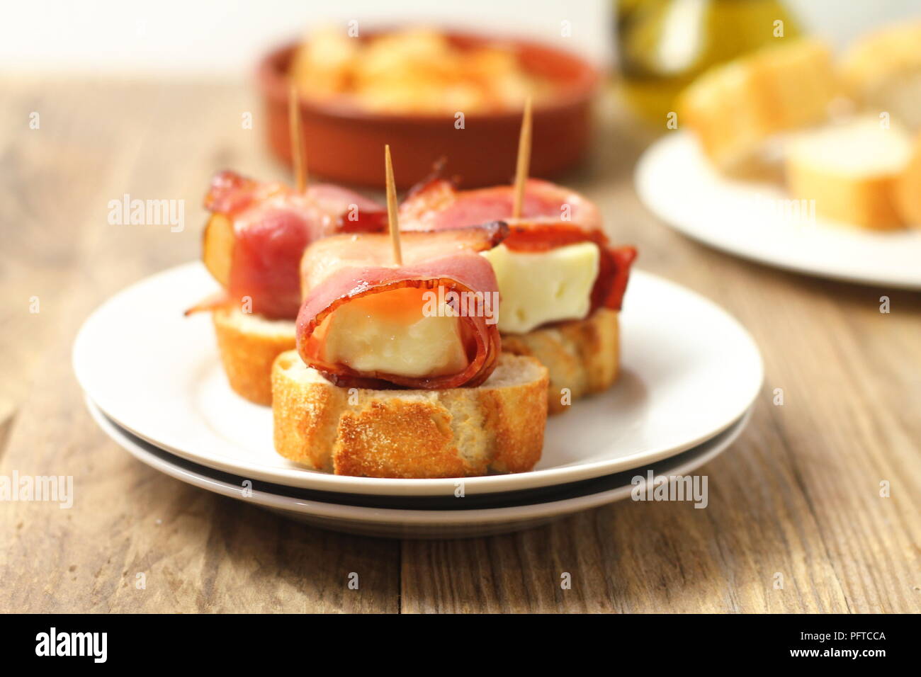 Spanish tapas - bites made of bread, melted cheese and bacon, with fried  almonds and olives Stock Photo - Alamy