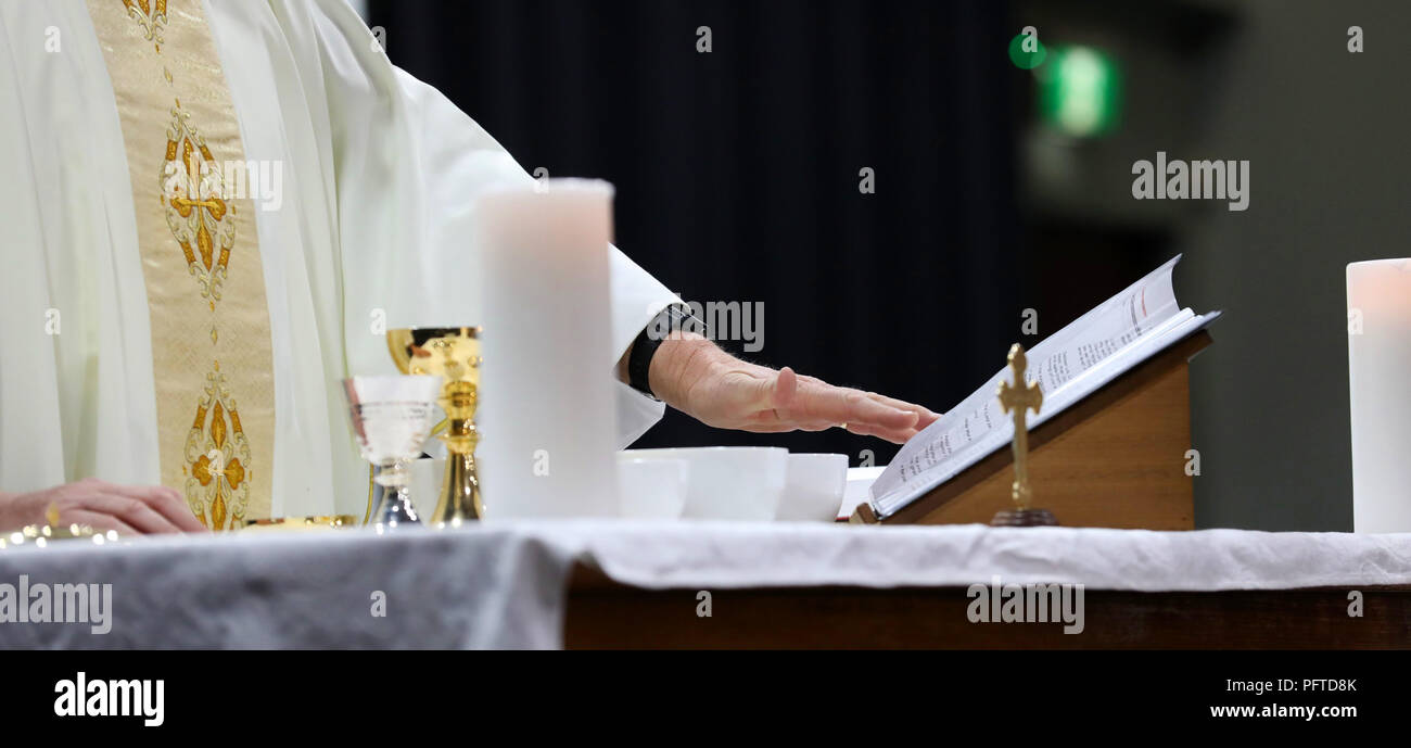 catholic priest hands serving mass at a liturgy. Images shows various symbols of Catholicism, religious values and objects. Religion religious Stock Photo