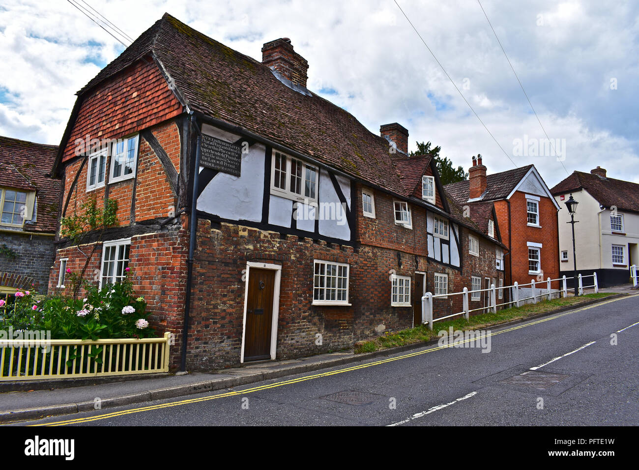 An old cottage on Bridge Road leading up to Wickham's square. An interesting old wall plaque threatens severe punishment to vagrants found nearby! Stock Photo