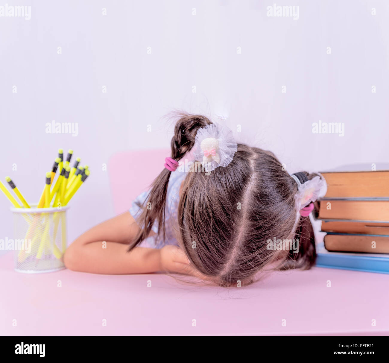 Cute little girl in school uniform sleeps on books.Selective focus and copy space for editing Stock Photo