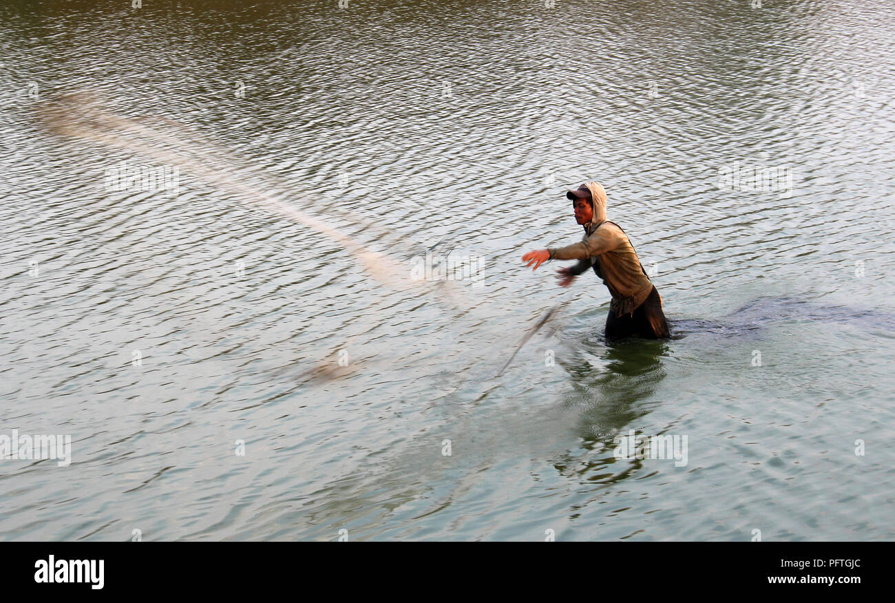 Fisherman tossing net on pond at Bojongsoang, Bandung, Indonesia Stock Photo
