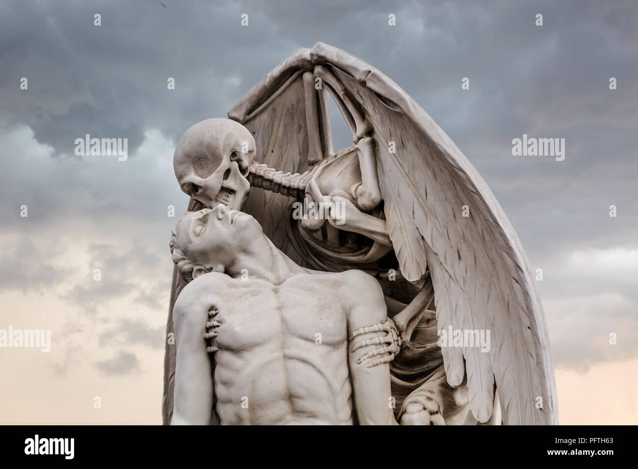 The Kiss of Death statue in Poblenou Cemetery in Barcelona. This marble sculpture depicts death, as a winged skeleton, kissing a handsome young man. Stock Photo