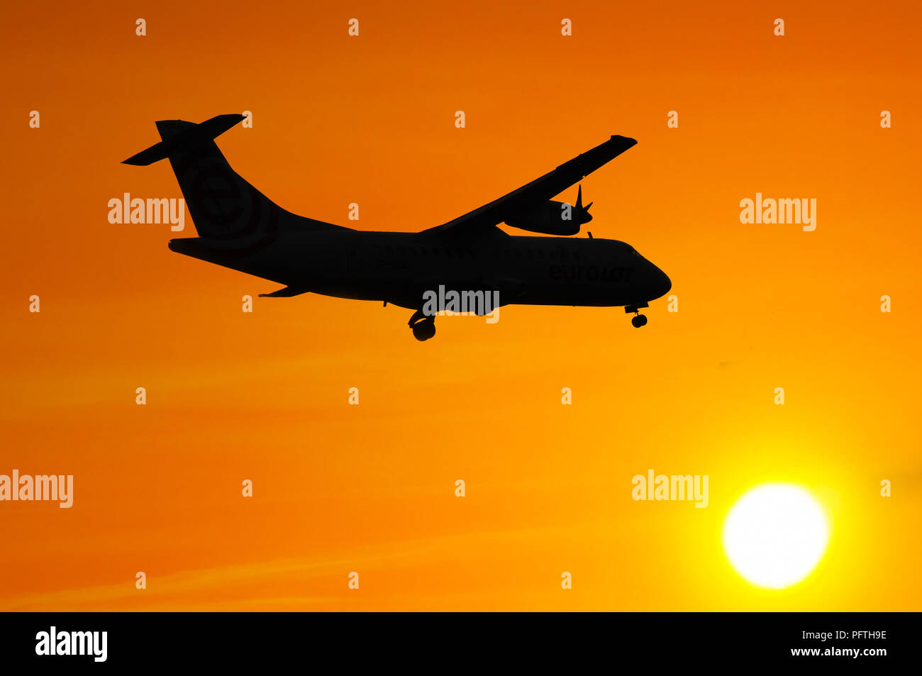 Airplane in the sky at sunset. Silhouette of an airplane on sunset background Stock Photo