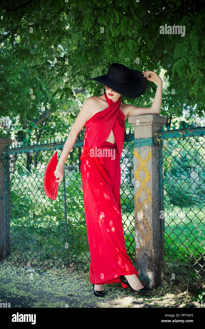 Young beautiful glamorous girl with black hat and red wardrobe set Stock Photo