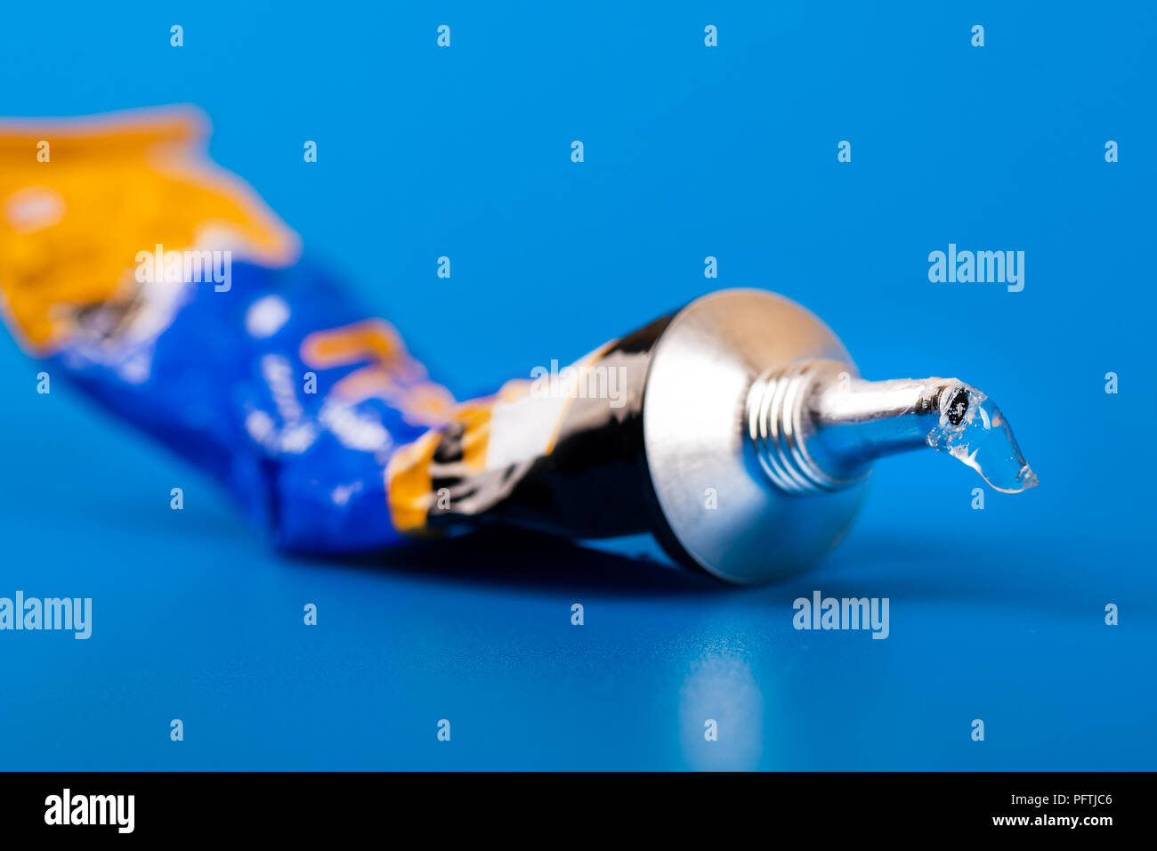 super glue tube on blue background Stock Photo