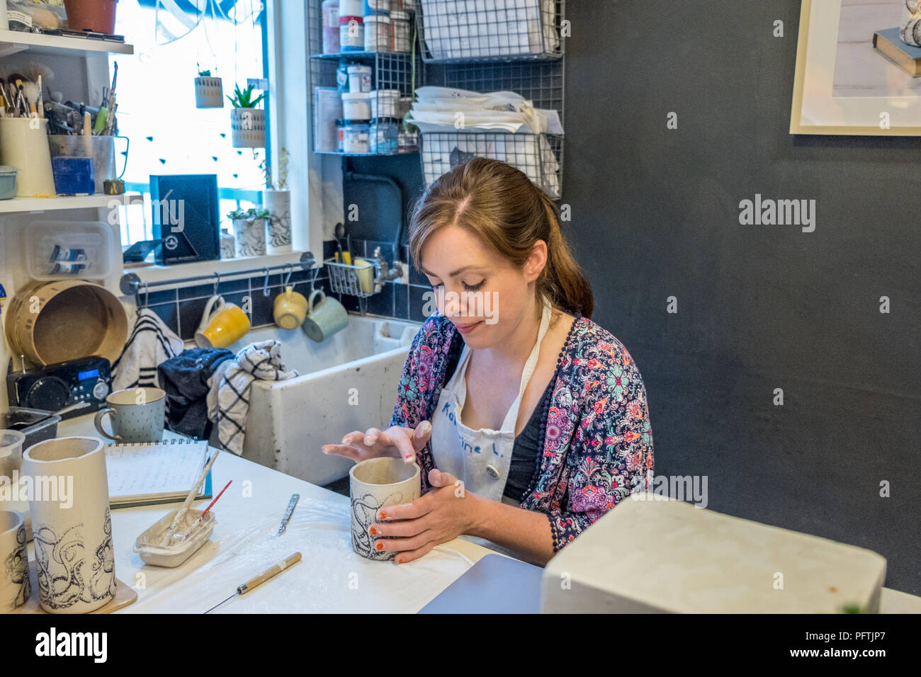 A young lady working in her workshop making ceramic jugs Stock Photo