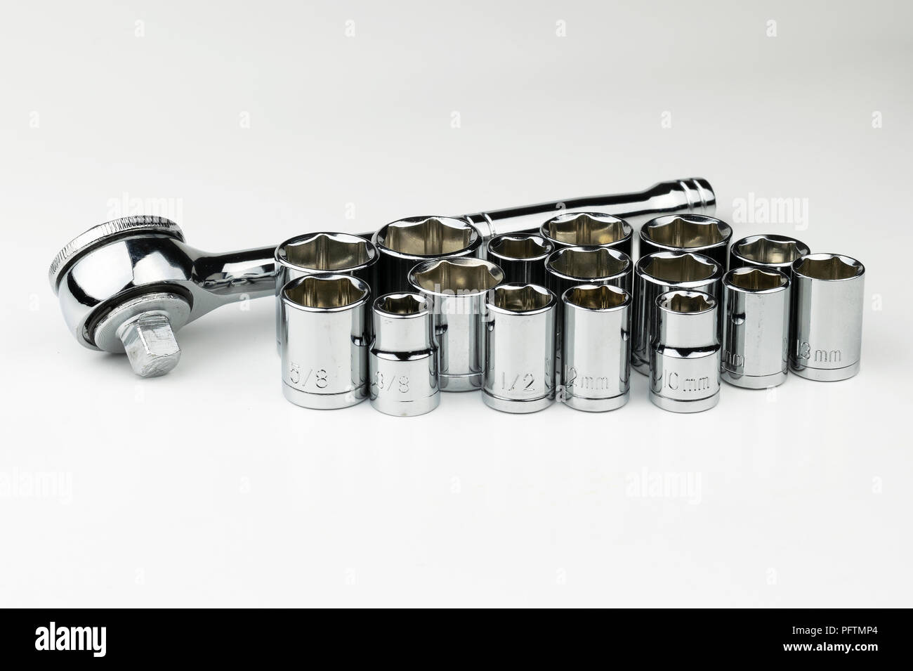 A shiny, silver, chrome socket wrench set with both SAE fractional sockets and metric sockets in millimeters on a white background like an automobile  Stock Photo