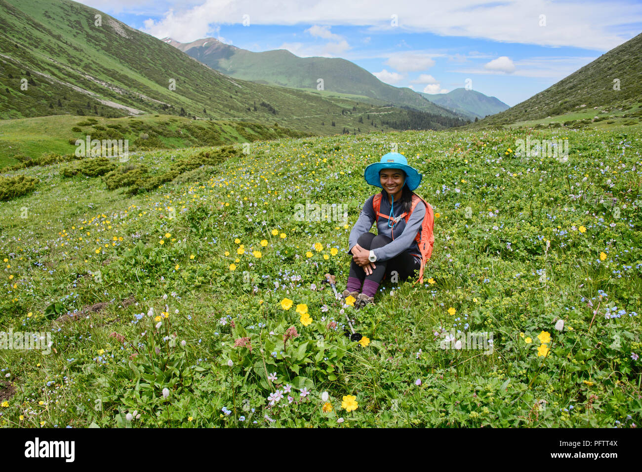 Enjoying the fields of wildflowers on the alpine Keskenkija Trek, Jyrgalan, Kyrgyzstan Stock Photo