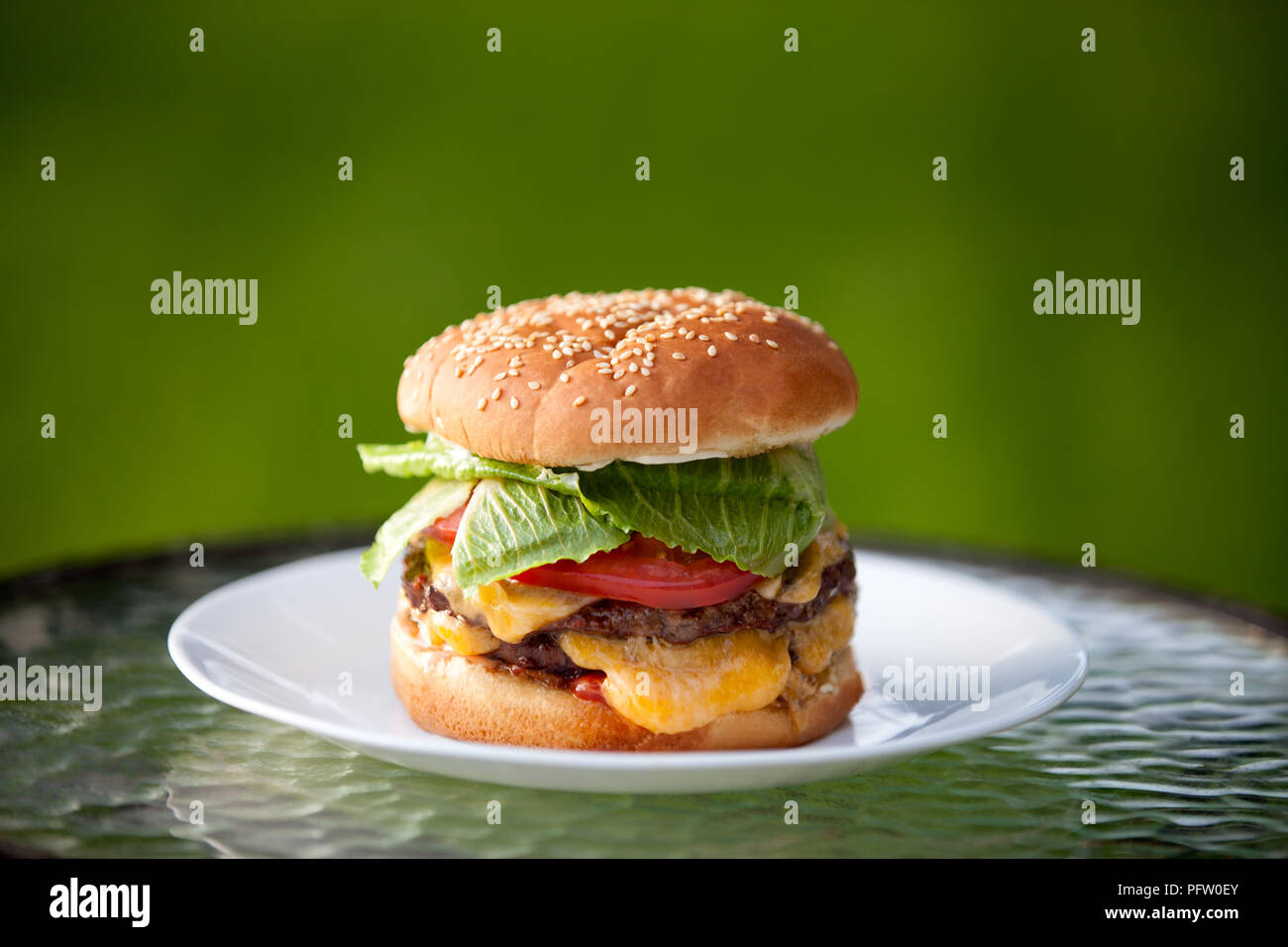Big Cheeseburger with melted cheese and sesame bun Stock Photo