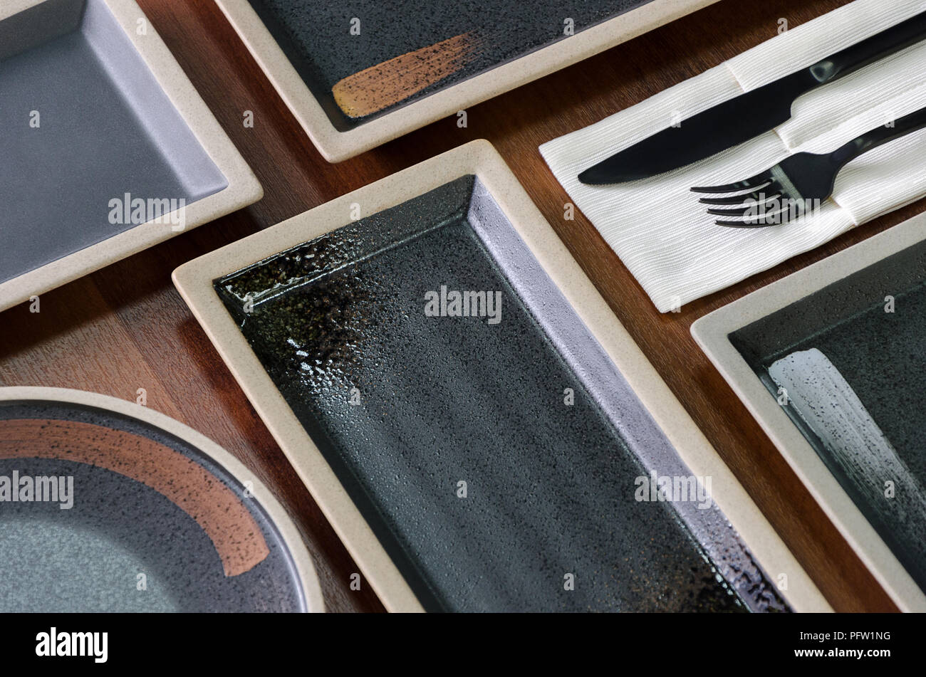 Square dishes of dark color on the table Stock Photo