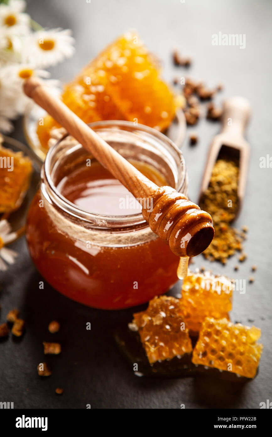 Honey jar and dipper with leaking honey Stock Photo Alamy