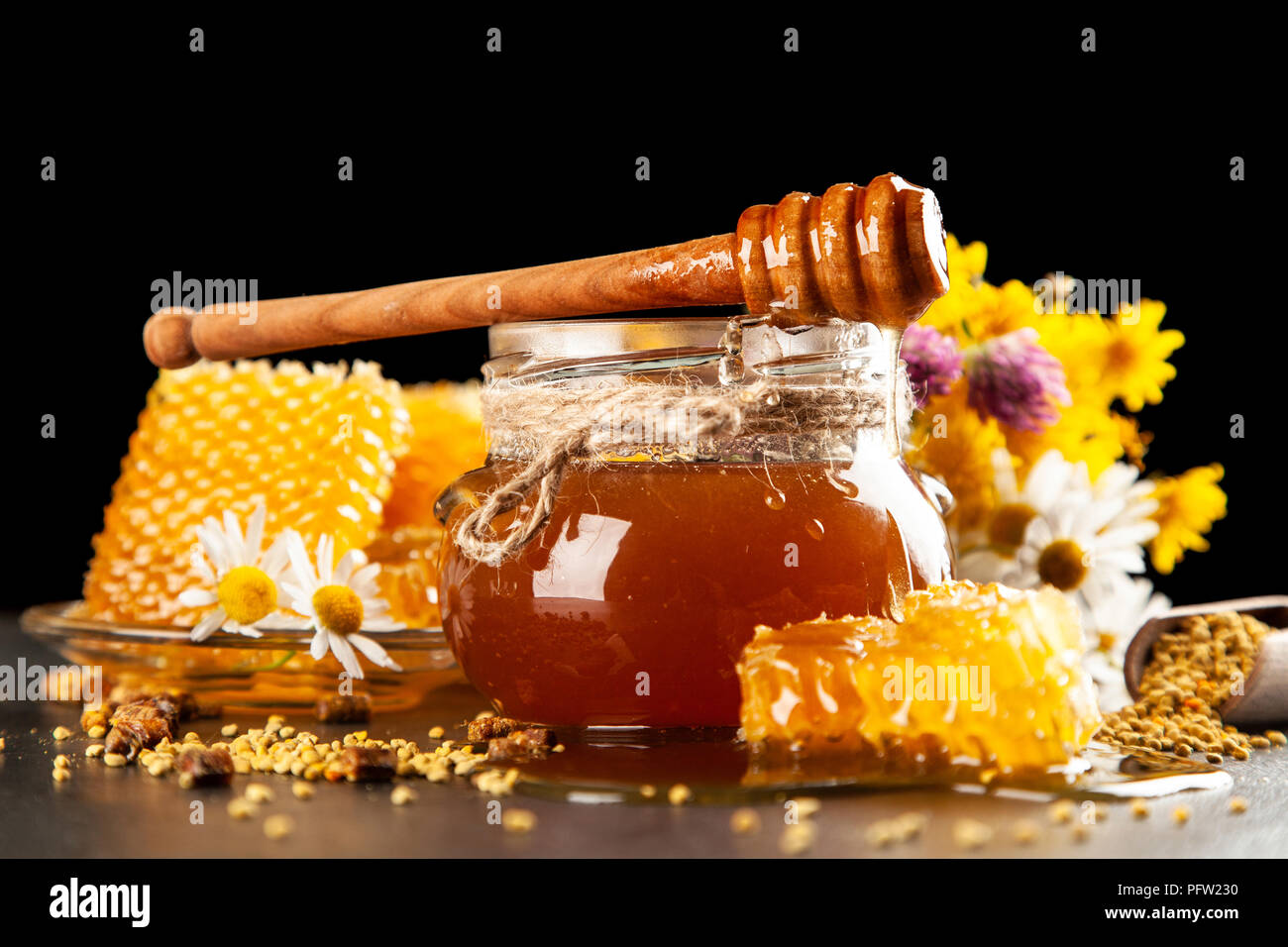 Honey jar and dipper with leaking honey Stock Photo Alamy