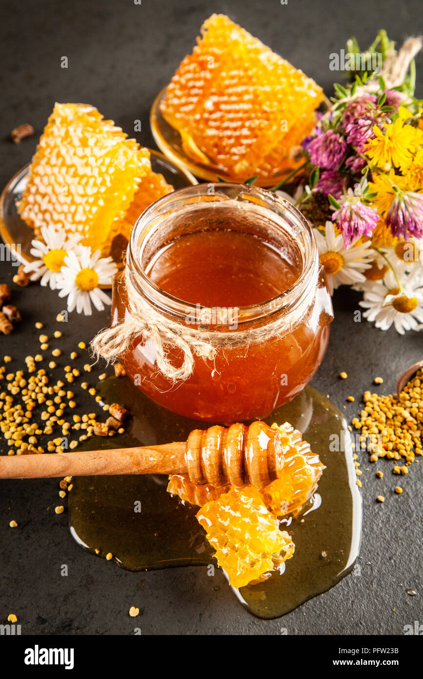 Honey jar and dipper with leaking honey Stock Photo - Alamy