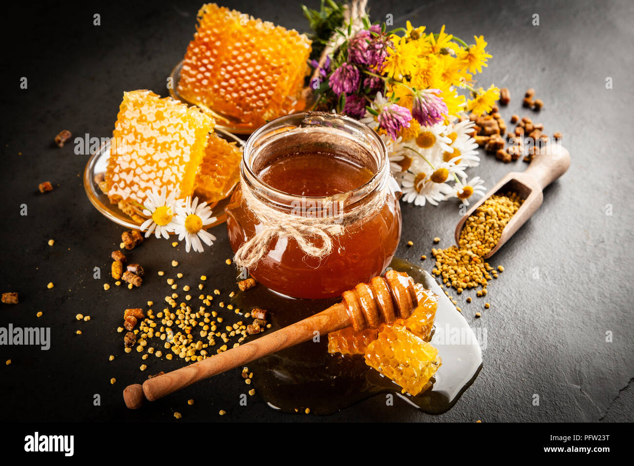 Honey jar and dipper with leaking honey Stock Photo - Alamy