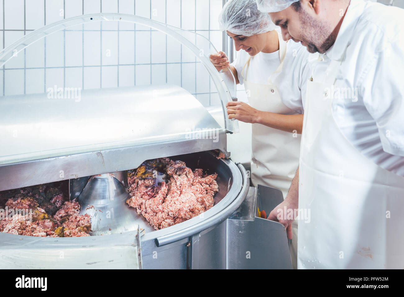 Butchers in butchery processing meat Stock Photo