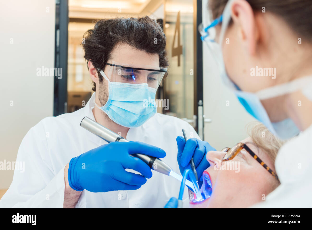 Dentists hardening toot crown with UV light  Stock Photo