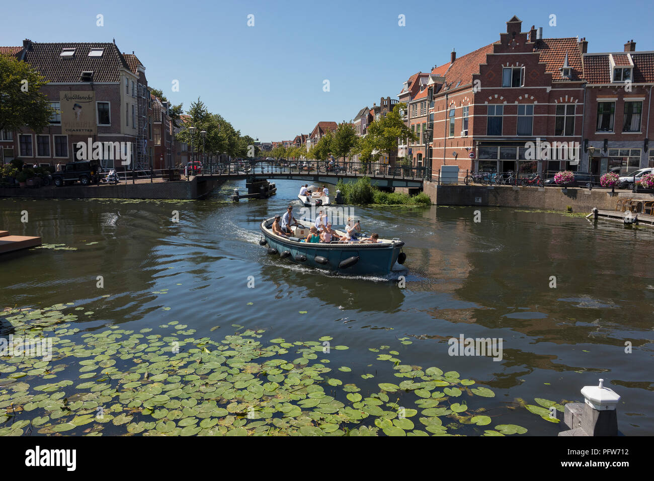 Leiden, Netherlands - August 3, 2018: Pleasure vessels at a Leiden historic canal, Oude Rijn, in summer Stock Photo