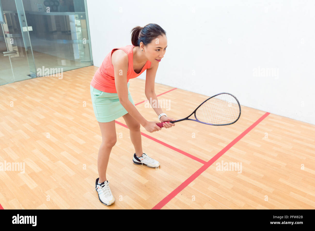 Young squash player holding the racket during game on a professional court Stock Photo