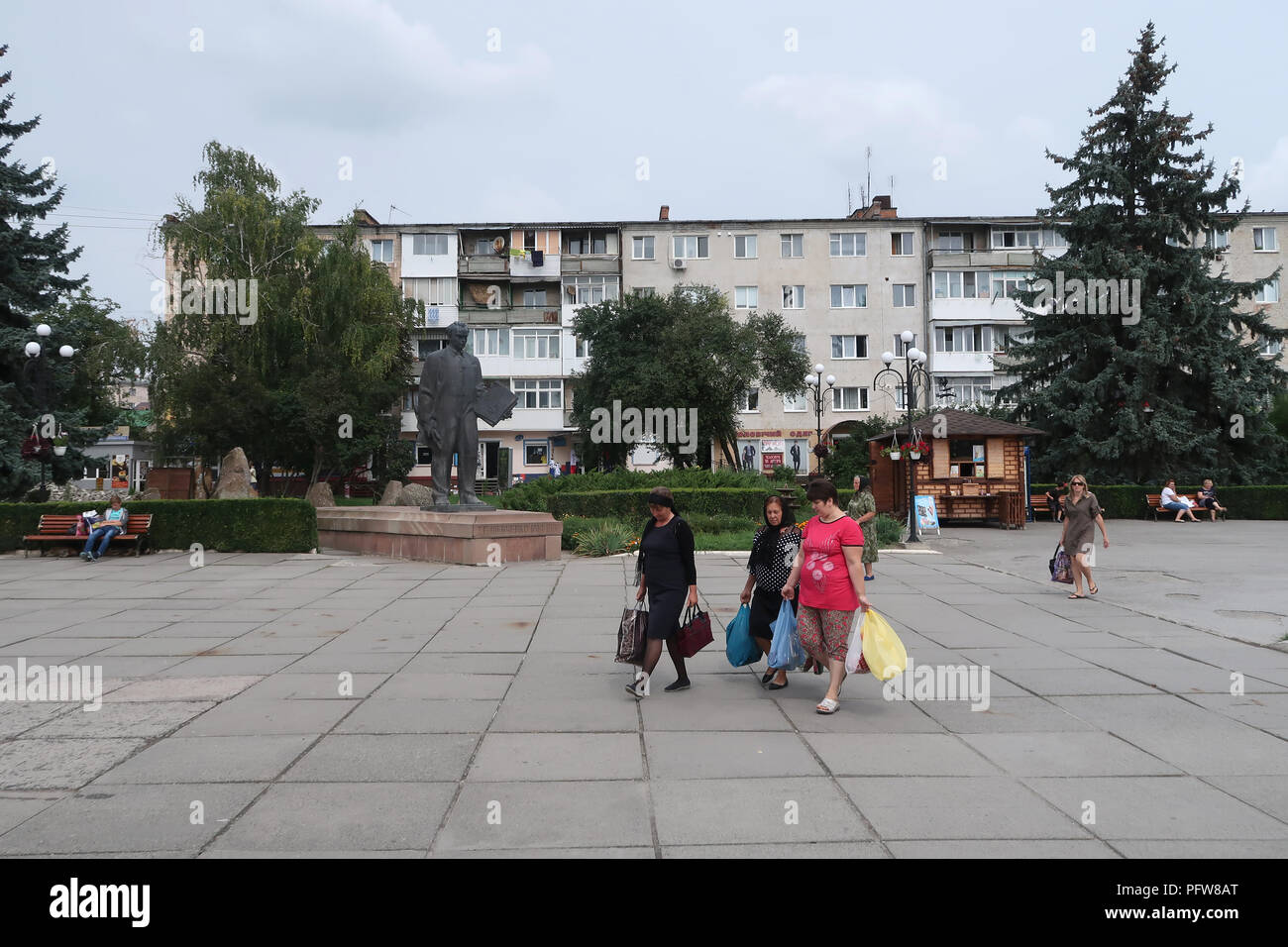 Pedestrians walk past monument to Taras Shevchenko who was a notable Ukrainian poet and writer in the city of Chortkiv which was once home to a large Jewish community and was annihilated, brutally, by the Germans during the Second World War in Ternopil Oblast (province) in western Ukraine. Stock Photo
