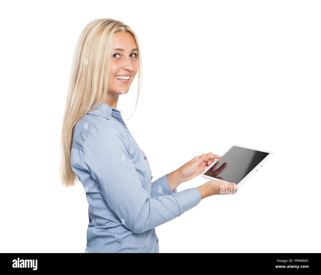 a young blonde woman with blue eyes holds a tabletbook in her hands and laughs at the camera, white background, isolated Stock Photo