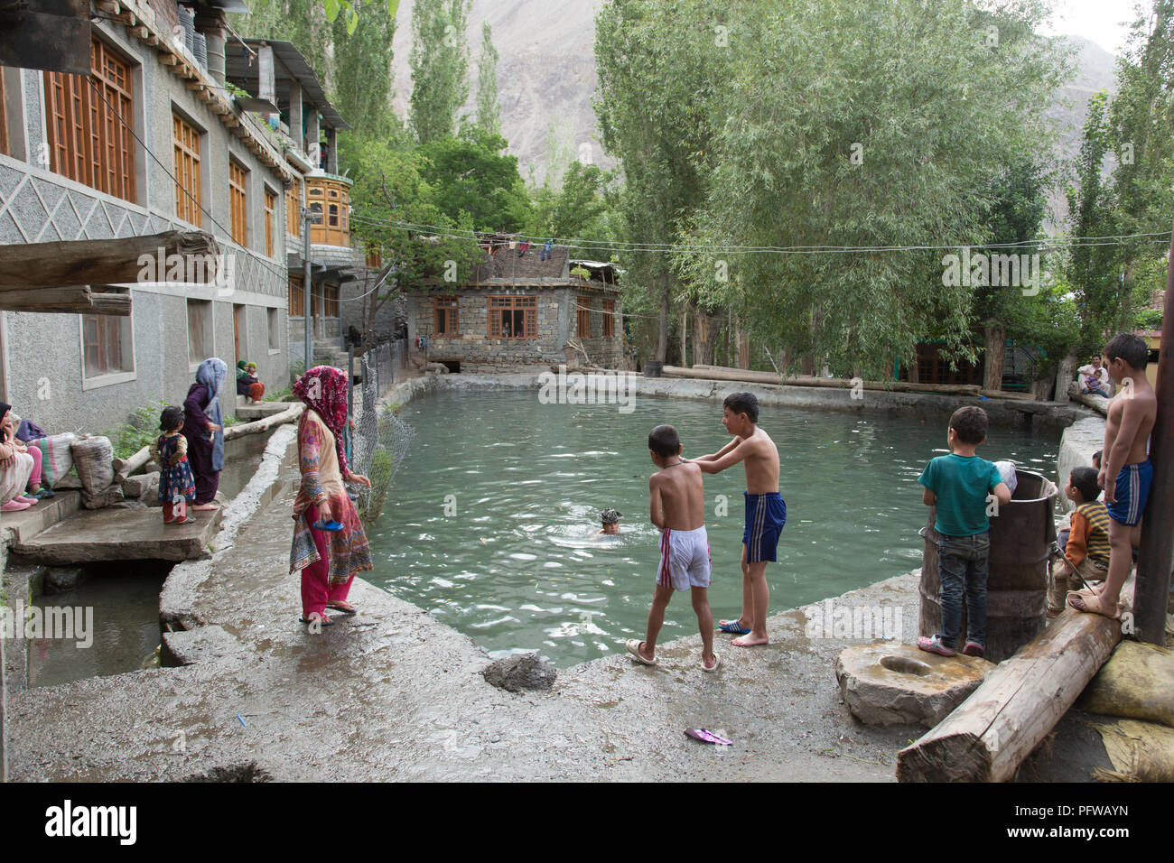 Children bathing at a water tank in Turtuk village, Shyok valley, Ladakh, Jammu & Kashmir, India Stock Photo