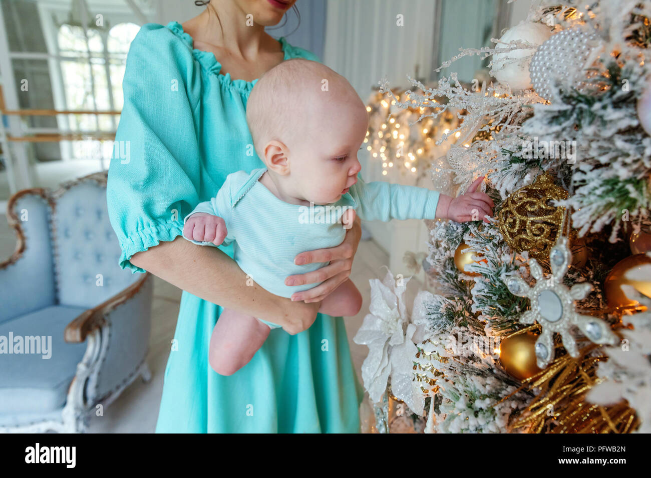 Happy family mother and daughter decorating Christmas tree on Christmas
