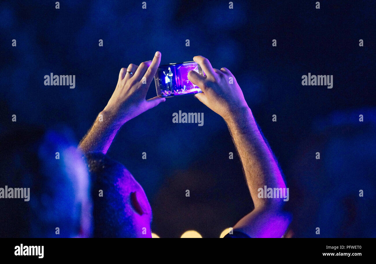 Montreal,Canada,18 August,2018.Spectator making a video of an outdor concert at night with a smartphone.Credit:Mario Beauregard/Alamy Live News Stock Photo
