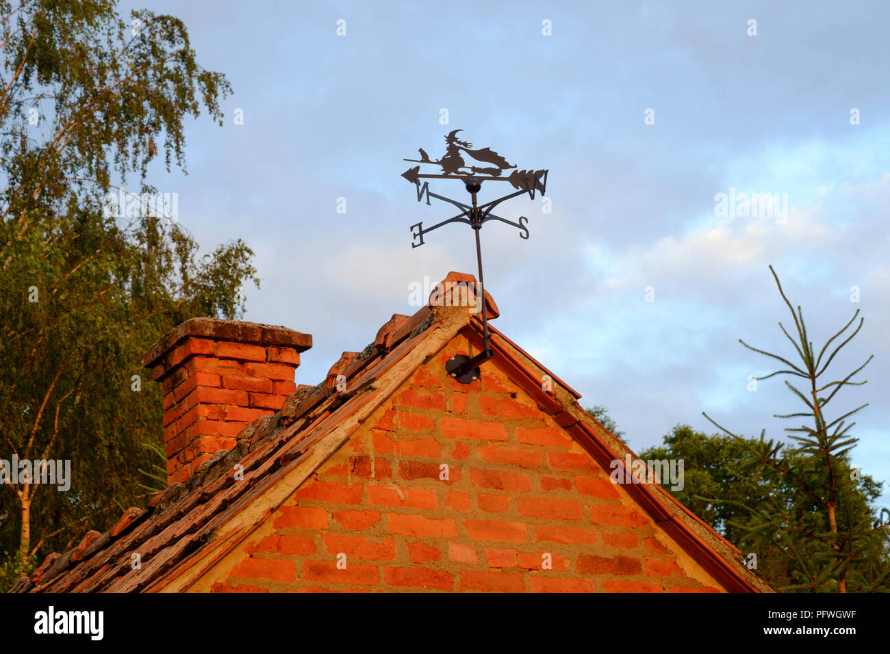 weather vane designed as a witch with black cat on a broomstick mounted on a gable end of building zala county hungary Stock Photo