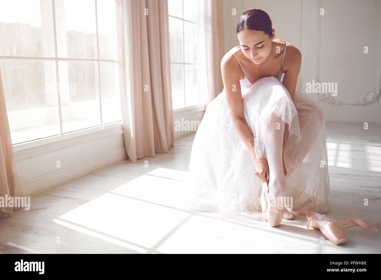 Pointe shoes on the feet of a ballerina. Stock Photo