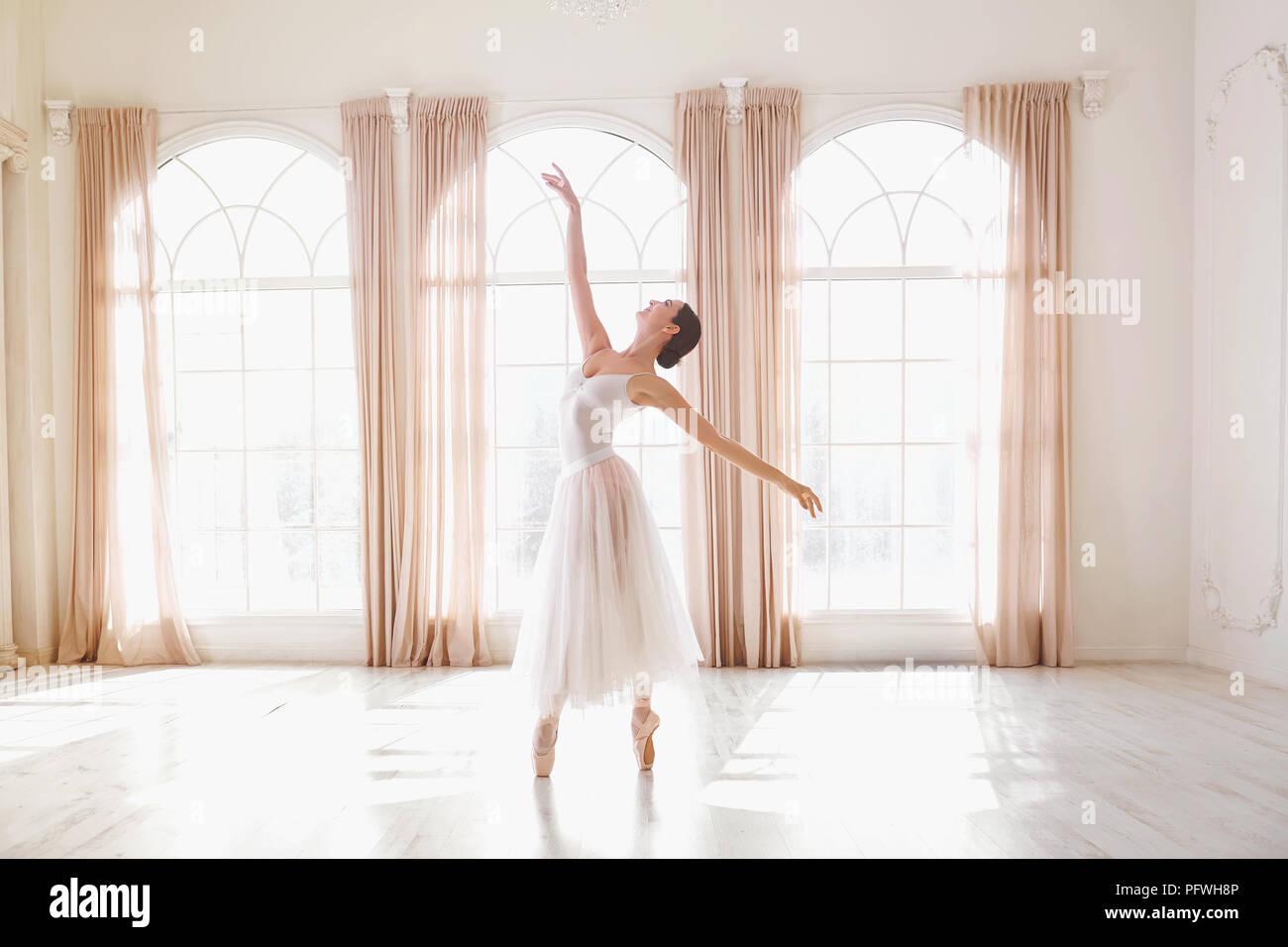 Ballerina dancing in a studio on background window Stock Photo - Alamy
