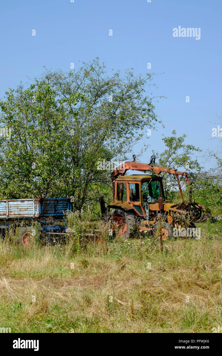 old obsolete rusting farm machinery abandoned in a rural field zala county hungary Stock Photo