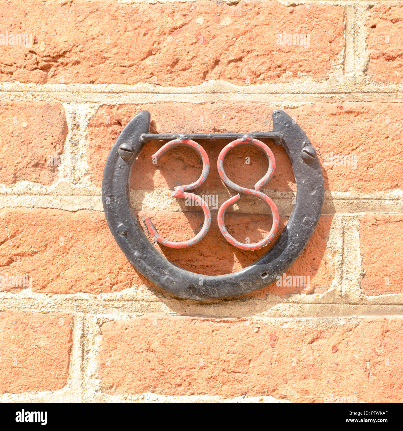 House number 38 sign inside horseshoe for luck Stock Photo