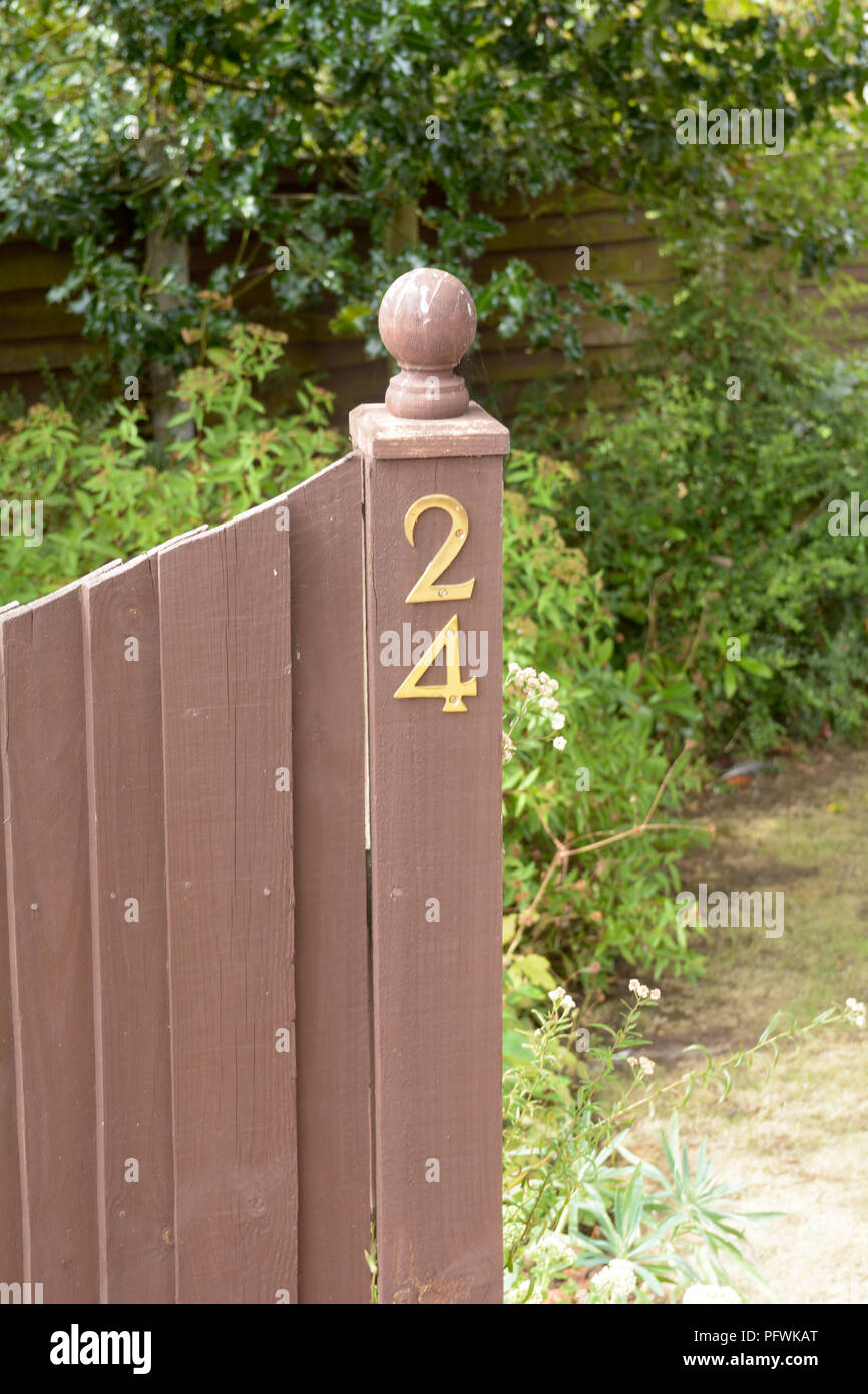 House number 24 sign fixed to wooden gate post Stock Photo