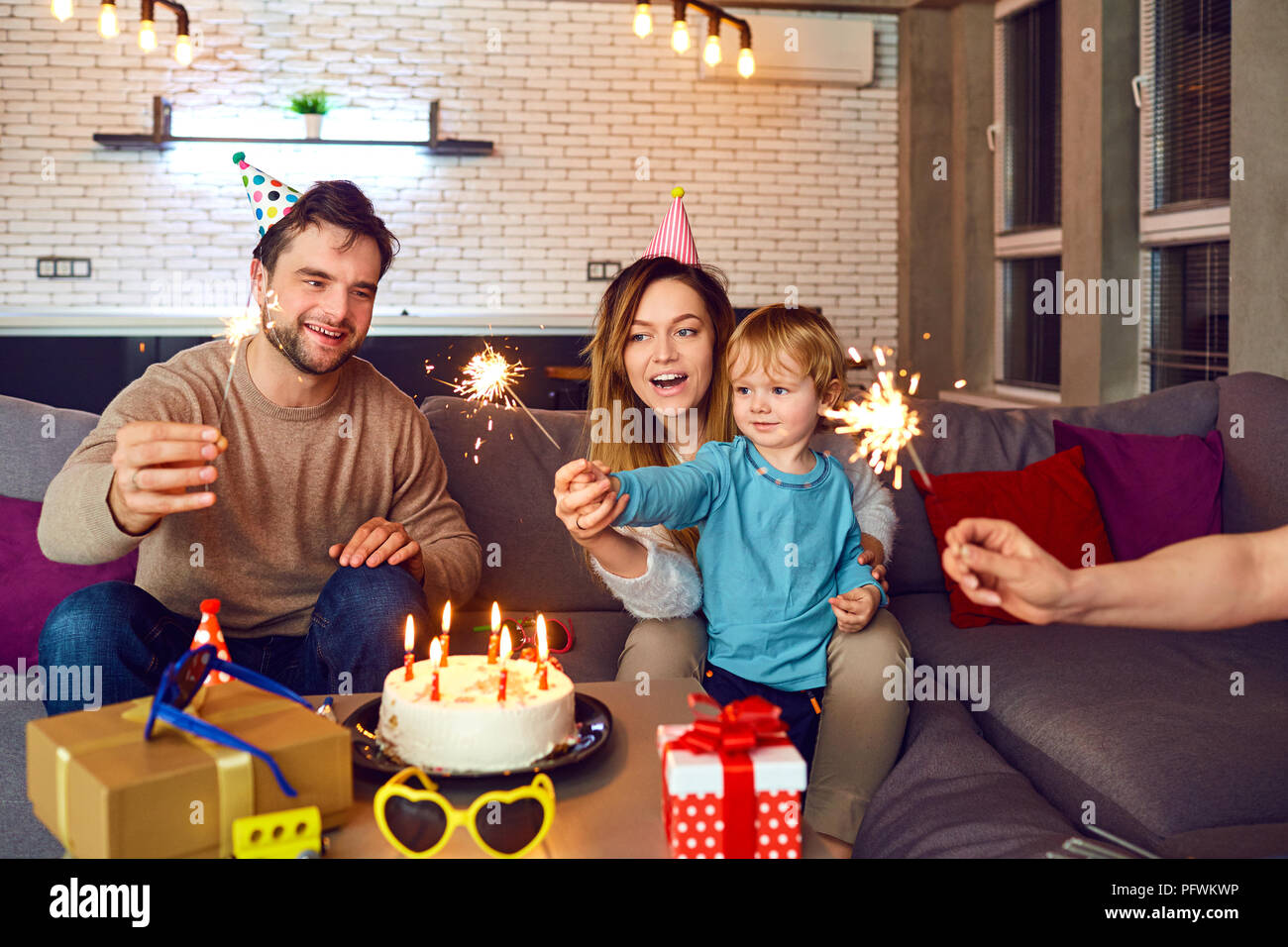 Parents with birthday cake congratulate their child. Stock Photo