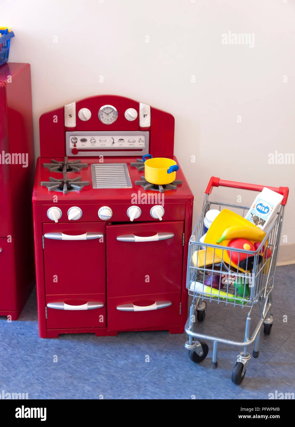 Cooktop stove, oven, refrigerator and shopping cart toys for children. Stock Photo