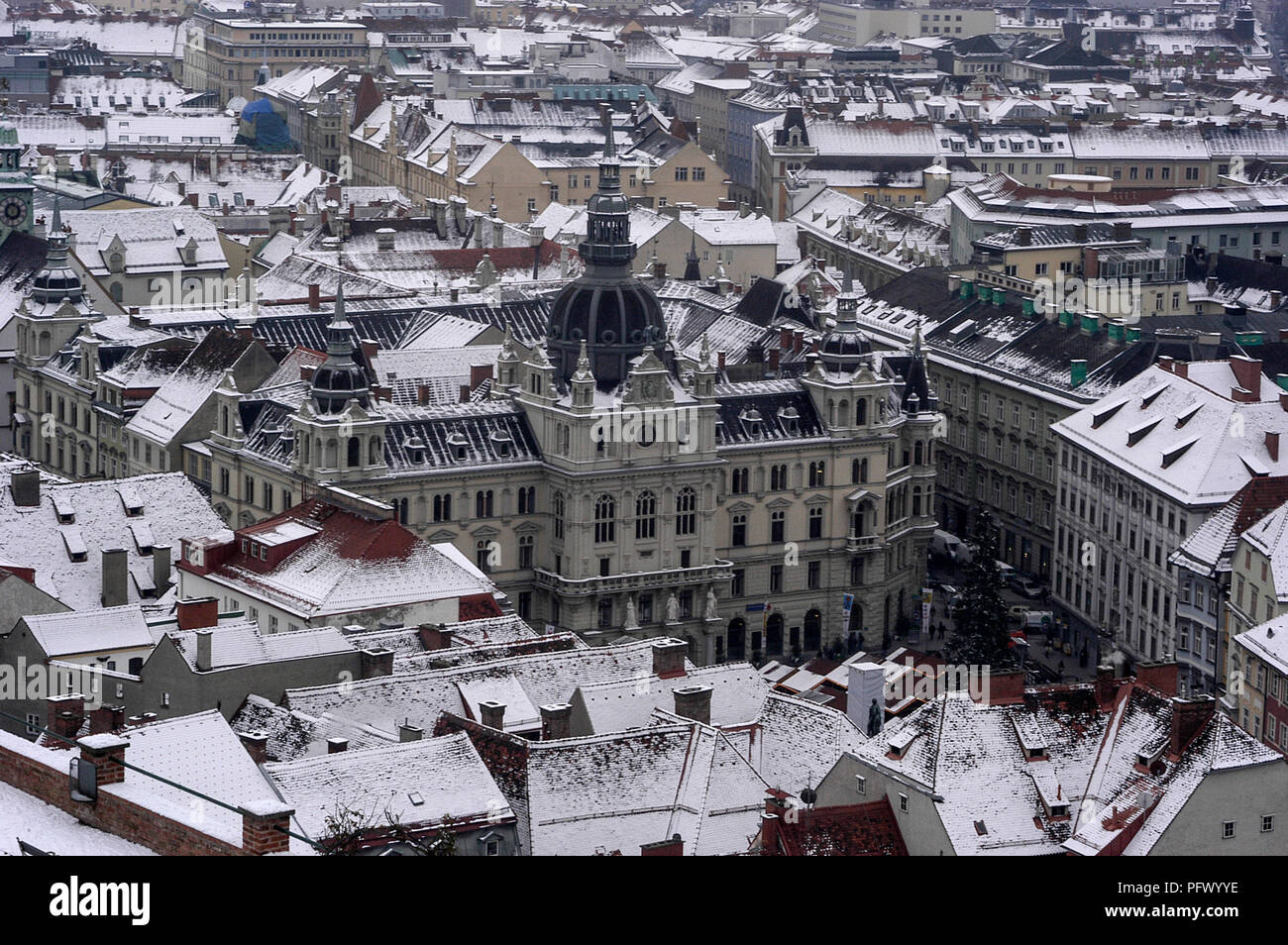 The dome high above the snow-covered roofs is the Graz City Hall in the ...