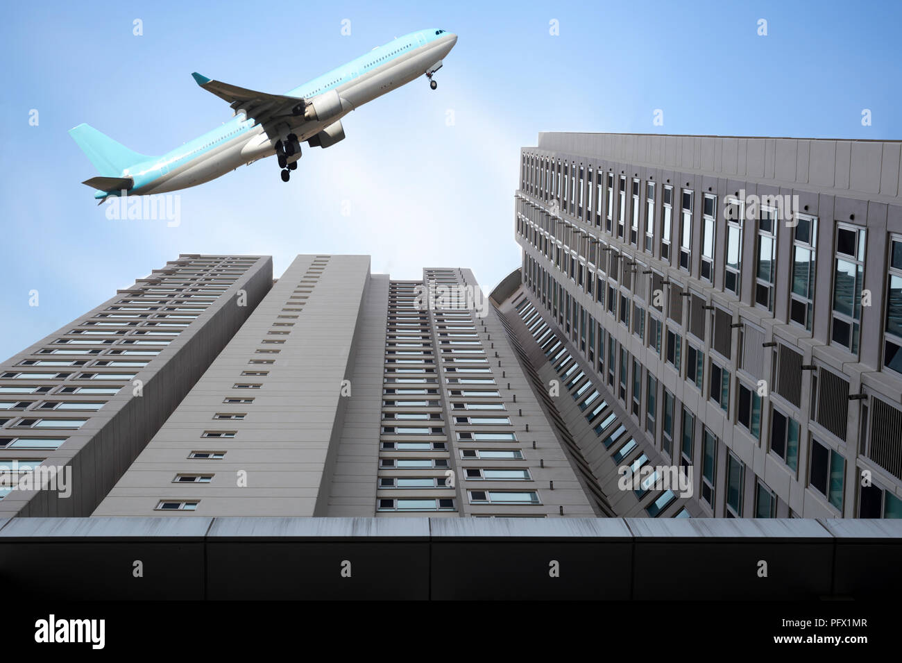 Airplane flying over high buildings hires stock photography and images