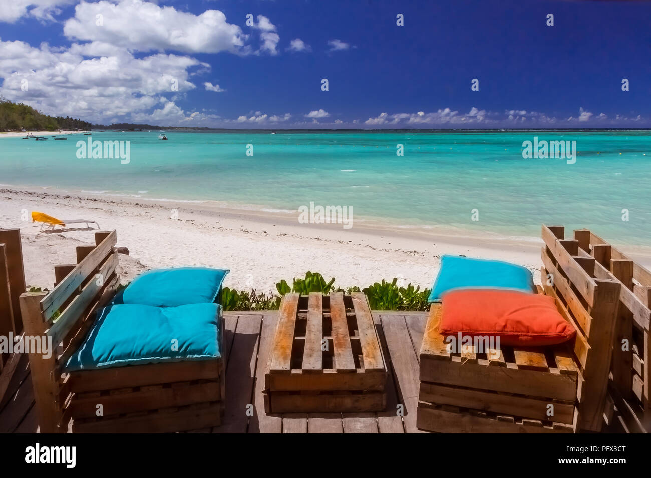 Wooden Benches With Coloured Pillows In A Bar On A Beach On