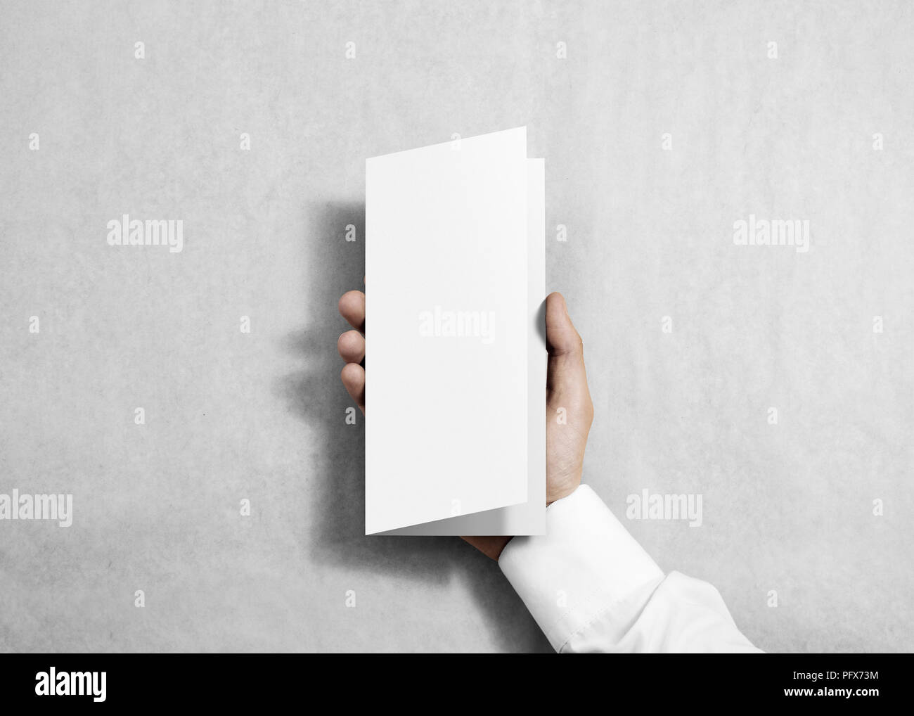 hand holding blank white flyer brochure booklet in the hand leaflet